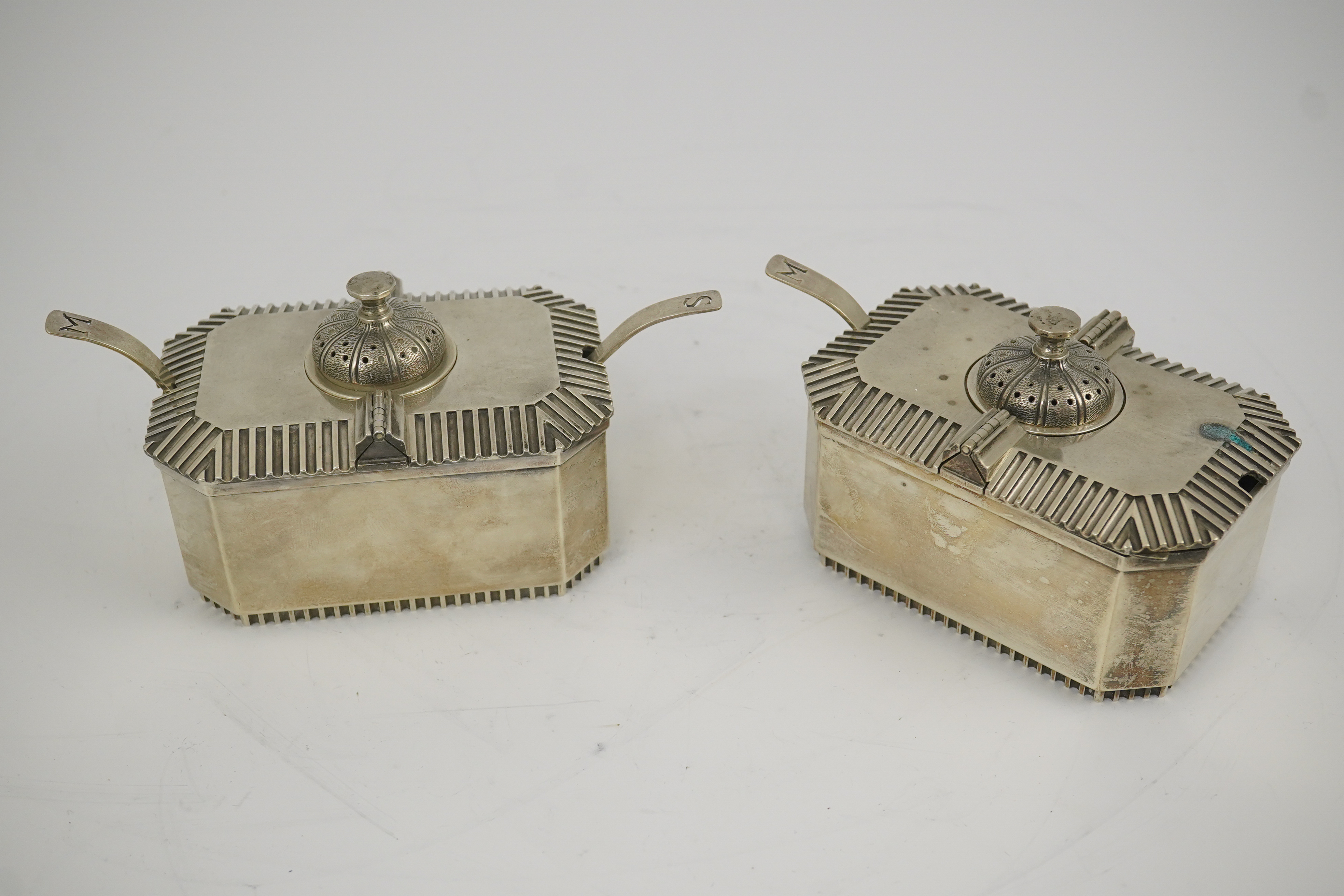 A pair of Elizabeth II silver double lidded condiments and matching spoons, by Hennell, Frazer & Haws